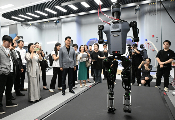 Seoul Mayor Oh Se-hoon, seventh from left, watches Tiangong, an electronically driven humanoid, move at the Humanoid Robot Innovation Center in Beijing on Wednesday. [SEOUL METROPOLITAN GOVERNMENT]