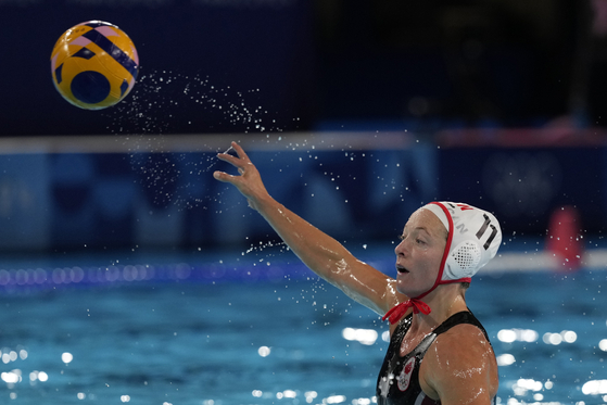 Canada's Kindred Paul makes an attempt to score during a women's water polo Group A match against the Netherlands in Paris on Sunday. [AP/YONHAP]