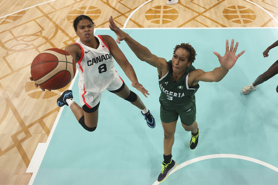 Cassandre Prosper of Canada shoots over Pallas Kunayi Akpanah of Nigeria in a women's basketball game in Villeneuve-d'Ascq, France on Sunday.  [AP/YONHAP]