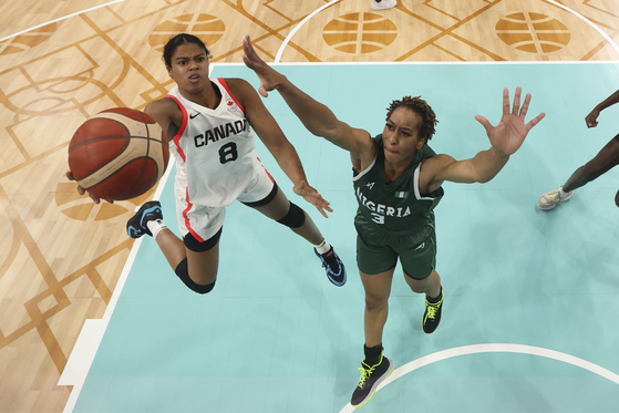 Cassandre Prosper of Canada shoots over Pallas Kunayi Akpanah of Nigeria in a women's basketball game in Villeneuve-d'Ascq, France on Sunday. [AP/YONHAP]