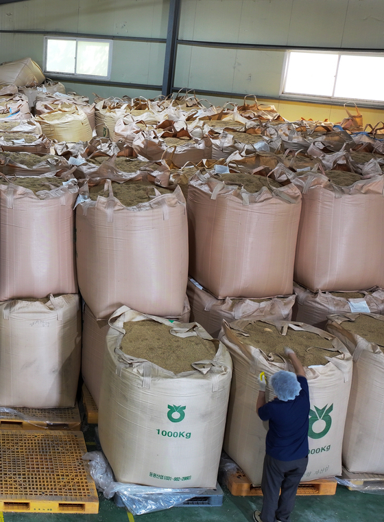 An employee inspects stacked piles of rice at a rice processing complex in Gangwon on Monday.[YONHAP]