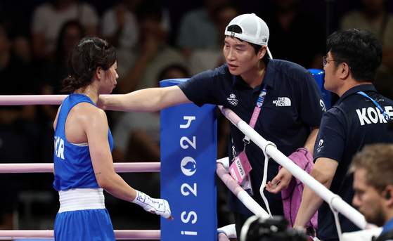 London Olympics men's lightweight silver medalist Han Soon-chul, center, comforts Im Ae-ji after she lost her semifinal bout against Turkey's TK at the Paris Olympics on Sunday.