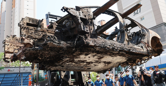 The burnt Mercedes EQE sedan is transferred for investigation in Incheon on Monday. [YONHAP]