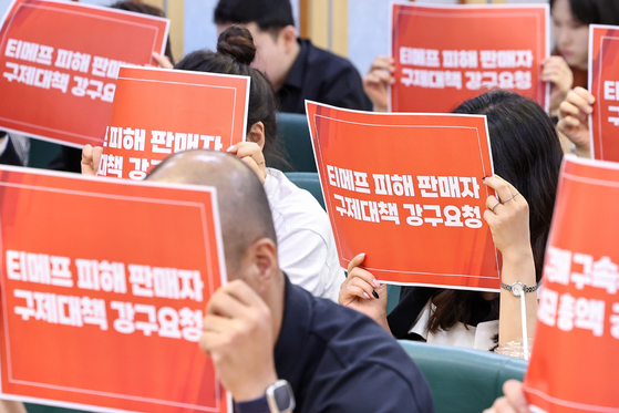 Merchants affected by delayed payments from TMON and WeMakePrice hold up signs with text demanding relief measures at the inauguration ceremony of the emergency committee created for the sellers' damage relief on Tuesday. [NEWS1]