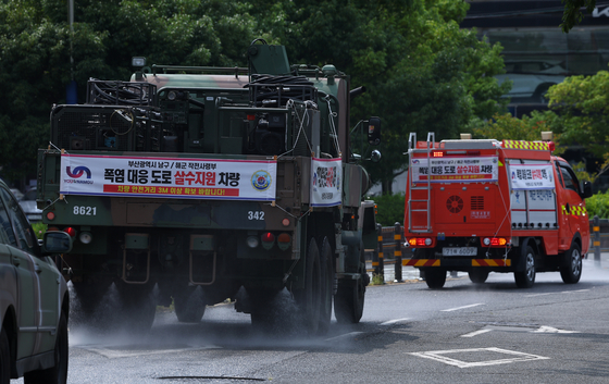 A K-10 decontamination truck sprays water on streets in Nam District, Busan, on Tuesday. [YONHAP]