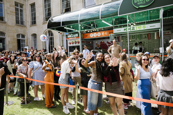 A crowd of people line up to enter a Bibigo booth. [CJ]