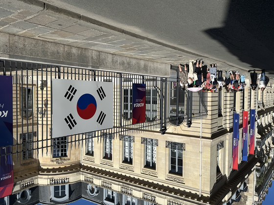 Visitors line up outside Korea House 30 minutes before the doors open in Paris on Monday. [JIM BULLEY]