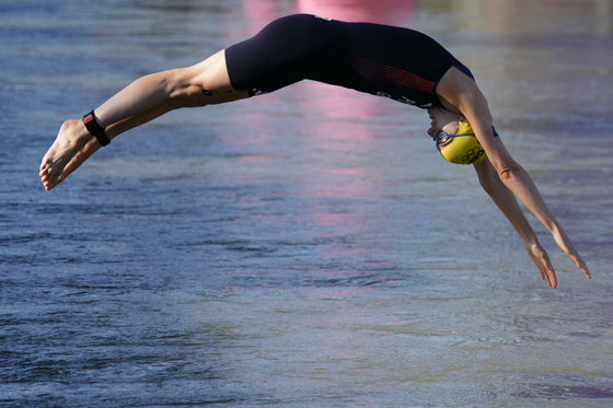 Britain's Beth Potter jumps into the water to compete in the swimming section of the mixed relay triathlon in Paris on Monday. [AFP/YONHAP]