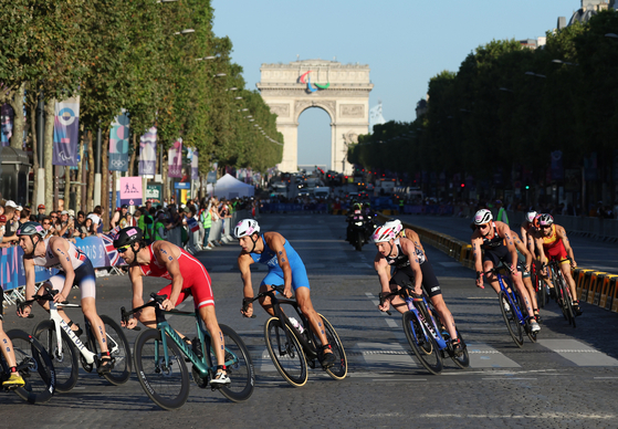 Athletes take part in the cycling stages the xixed triathlon on the 10th day of the Paris Olympics in Paris on Monday. [YONHAP]