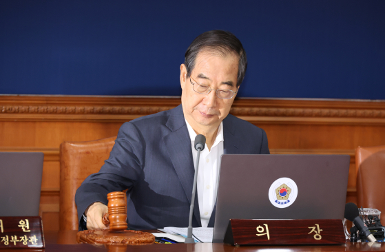 Prime Minister Han Duck-soo strikes his gavel at a Cabinet meeting held at the Central Government Complex in Jongno District, central Seoul, on Tuesday. [YONHAP]
