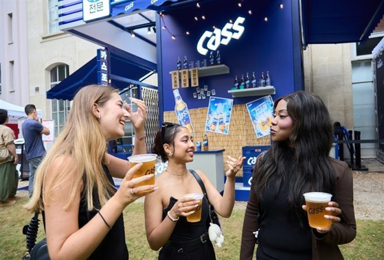 Visitors of OB's Cass booth enjoy cups of beer on the sidelines of a cultural exhibition at Korea House in Paris. [OB]