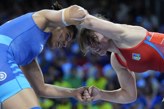 Ukraine's Tetiana Sova Rizhko and India's Nisha Nisha compete in the round of 16 of the women's freestyle 68-kilogram category at the Paris Olympics at Champ-de-Mars Arena in Paris on Monday. [AP/YONHAP] 