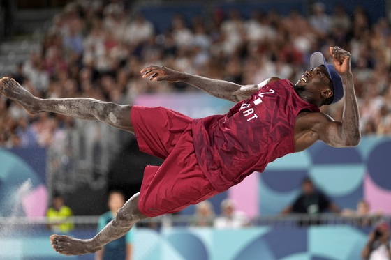 Qatar's Ahmed Tijan flies through the air after returning a shot against Chili in a beach volleyball match in Paris on Monday.  [AP/YONHAP]