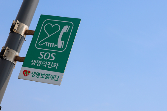 A board sign shows an emergency hotline phone installed on Mapo Bridge in western Seoul last September. [YONHAP] 