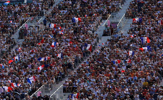 Spectators wave flags in the stands during the equestrian individual jumping qualifiers at Versailles in France on Monday.  [REUTERS/YONHAP]