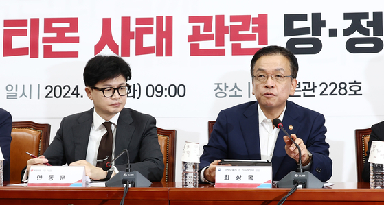 Minister of Economy and Finance Choi Sang-mok, right, and People Power Party leader Han Dong-hoon speak at a policy meeting held between the ruling People Power Party members and government officials at the National Assembly building in Yeouido, western Seoul on Tuesday. [NEWS1]