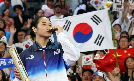  An Se-young poses with her gold medal after winning the women's individual badminton tournament at the 2024 Paris Olympics on Monday.  [YONHAP]