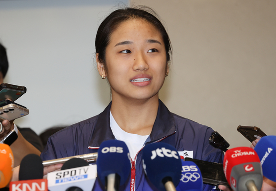 Korean badminton player An Se-young talks to reporters at Incheon International Airport in Incheon on Wednesday. [YONHAP]