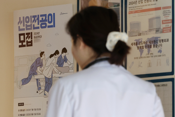 A medical professional walks in front of a recruitment poster at a general hospital in downtown Seoul on Wednesday. [YONHAP]