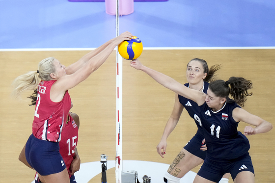 Jordyn Poulter of the United States, left, and Martyna Lukasik of Poland compete for the ball during a women's volleyball quarterfinal match in Paris on Tuesday. [AP/YONHAP]