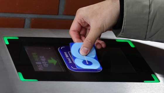 A commuter taps the Climate Card to enter the paid area of City Hall Station in Jung District, central Seoul, on Jan. 29, when the pilot period for the scheme began. [JOINT PRESS CORPS]