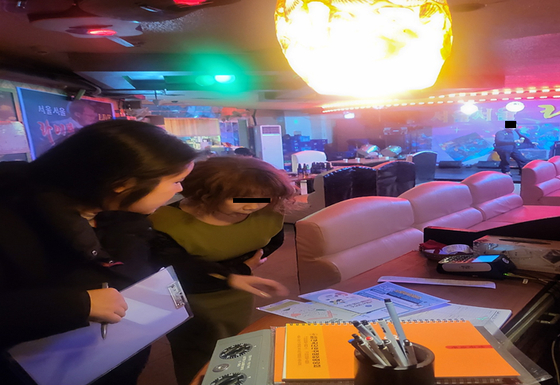 A city government official advises a bar owner on drug use prevention in an undated photo provided by the Seoul city government on Thursday. [SEOUL METROPOLITAN GOVERNMENT]