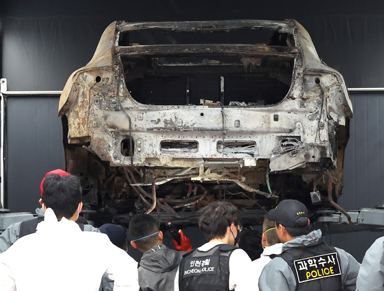 Police and fire authorities conduct an investigation on the burnt Mercedes EV on Thursday. [YONHAP]