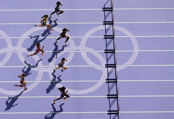 Athletes compete in the women's 100-meter hurdles the repechage round in Paris on Thursday.  [XINHUA/YONHAP]