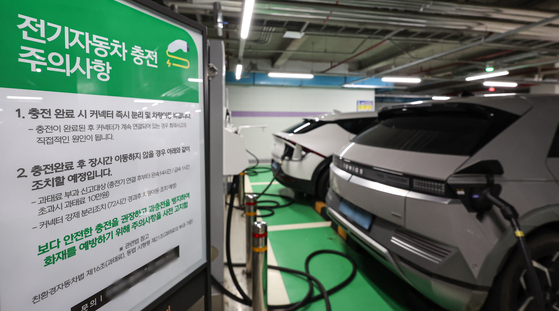 Electric vehicles are being charged at an EV charging station in an underground parking lot of a building in Seoul on Friday. [NEWS1]