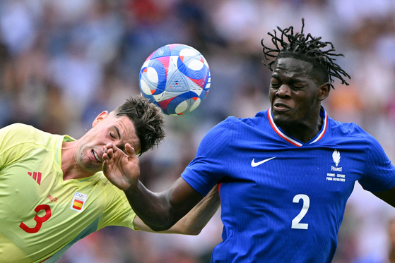 Spaish defender Juan Miranda heads the ball next to French defender Castello Lukeba in the men's gold medal football match in Paris on Friday. [AFP/YONHAP]