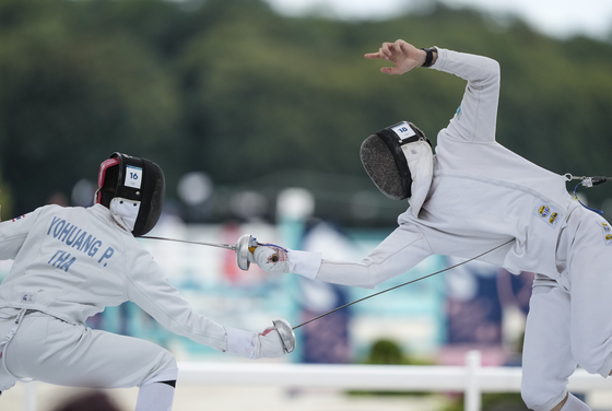 Kazakhstan's Georgiy Boroda-Dudochkin and Thailand's Phurit Yohuang compete in the men's individual fencing portion of the modern pentathlon in Versailles, France on Friday. [AP/YONHAP]