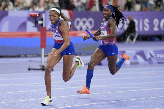 Gabrielle Thomas, left, of the United States reaches for the baton from teammate Twanisha Terry in the women's 4x100-meter relay final in Paris on Friday. [AP/YONHAP]