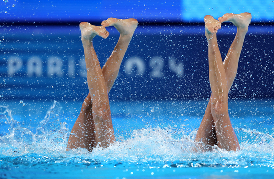 Liuyi Wang of China and Qianyi Wang of China perform in the artistic swimming duet technical routine in Paris on Friday. [REUTERS/YONHAP]