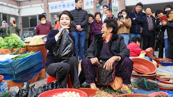 First lady Kim Keon Hee, left, purchases local produce from a traditional market in Suncheon, South Jeolla, on Wednesday, in a photo provided by the presidential office on Thursday. [PRESIDENTIAL OFFICE]