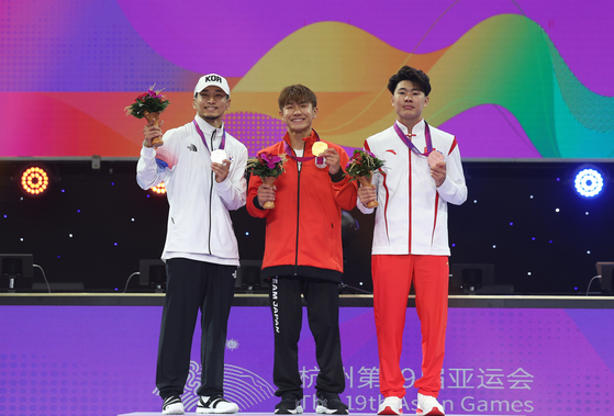 Hongten, left, poses with his silver medal on the podium at the Hanzhou Asian Games in Hangzhou, China on Oct. 7, 2023. [XINHUA/YONHAP]