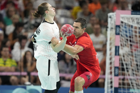 Germany's Juri Knorr, left, is challenged by Denmark's Rasmus Lauge during the gold medal handball match at the Paris Olympics on Sunday in Villeneuve-d'Ascq, France. [AP/YONHAP]