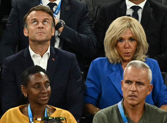 French President Emmanuel Macron, top left, and his wife, Brigitte Macron, react during the gold medal women's basketball game at the Paris Olympics on Sunday. [REUTERS/YONHAP]