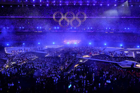 The Olympic rings are assembled and risen over the stage during the closing ceremony of the Paris Olympics at the Stade de France, in Saint-Denis, France on Sunday. [AFP/YONHAP] 