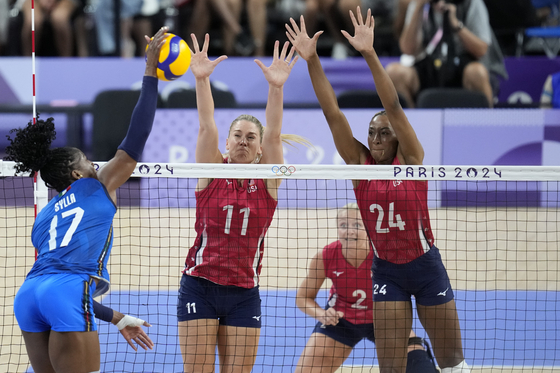 Chiaka Ogbogu of the United States, and Andrea Drews of the United States, block a ball from Myriam Sylla of Italy, from right, during a gold medal women's volleyball match at the Paris Olympics in Paris on Sunday. [AP/YONHAP] 