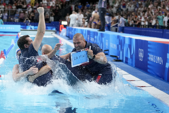 Serbia's head coach Uros Stevanovic is pushed into the pool as they celebrate winning the men's water polo gold medal match against Croatia at the Paris Olympics on Sunday in Paris. [AP/YONHAP]