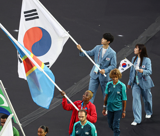 Taekwondo practitioner Park Tae-joon, left, and boxer Im Ae-ji enter Stade de France in Saint-Denis, France with the Korean flag for the Paris Olympics closing ceremony on Sunday. [NEWS1] 