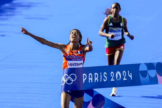 Sifan Hassan, left, of the Netherlands celebrates as she crosses the finish line to win the gold medal ahead of Tigst Assefa of Ethiopia, who won silver, in the women's marathon at the 2024 Paris Olympic Games in Paris. [UPI/YONHAP]