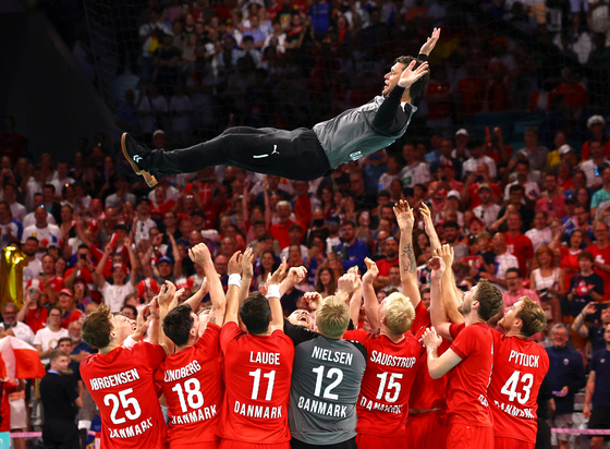 Denmark players throw team captain Niklas Landin Jacobsen in the air after they win the men's handball gold medal match against Germany at the Paris Olympics on Sunday. [REUTERS/YONHAP]