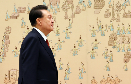 President Yoon walks down a corridor inside the presidential office in Yongsan District, central Seoul, on Monday. [JOINT PRESS CORPS]