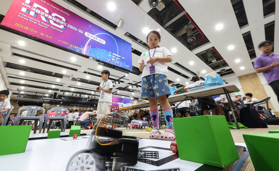 Competitors control robots they made themselves at the Korean division of the 2024 International Robotics Olympiad (IRO) held at the EXCO convention center in Daegu on Monday. [YONHAP]