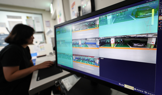 An official checks thermal cameras installed in an EV charging area in a public parking lot in southern Seoul on Tuesday. [NEWS1] 