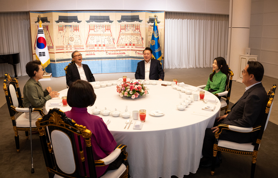 President Yoon Suk Yeol, center right, and former President Lee Myung-bak, center left, chat during a dinner meeting at the official presidential residence in Seoul on Monday evening. [PRESIDENTIAL OFFICE]