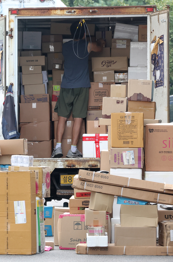  A delivery worker loads boxes onto a truck in Songpa District, southern Seoul, on Tuesday. [YONHAP]