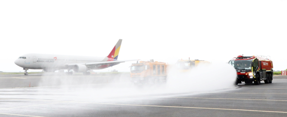 Water trucks conduct a drill of spraying water on the runway at Jeju International Airport on Wednesday. Runway temperatures typically hover around 50 degrees Celsius (122 degrees Fahrenheit), but when they exceed 60 degrees Celsius, it becomes crucial to sprinkle water to cool the surface. The Korea Meteorological Administration conducted a special inspection on Friday and discovered that road surfaces exposed to the sun at Boramae Park in Dongjak District, southern Seoul, reached up to 45.5 degrees Celsius.[NEWS1]