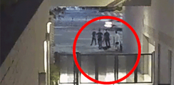 Three police officers are seen approaching Min Yoon-gi, known by his stage name Suga, in Yongsan District, central Seoul on Aug. 6. The video clip was released by local newspaper Dong-A Ilbo on Wednesday. [SCREEN CAPTURE]